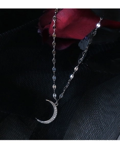 Close-up of S925 sterling silver moon anklet with zircons on dark rose background
