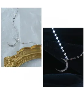 Detail of s925 silver moon anklet with cubic zirconia and flat disk chain links