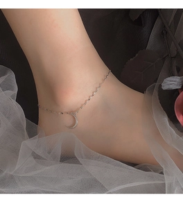 Detailed view of S925 sterling silver moon anklet with pavé zircons on a woman's ankle
