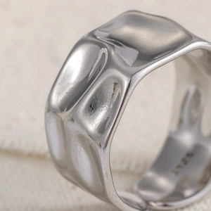 Macro shot of S925 sterling silver ring featuring irregular hammered texture and wide band