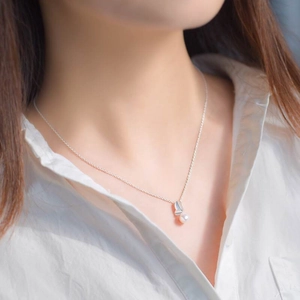 Élégant collier en argent s925 avec pendentif feuille et perle, porté par un mannequin