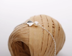 Vue macro du bracelet à pendentif feuille d'argent avec une perle blanche lustrée