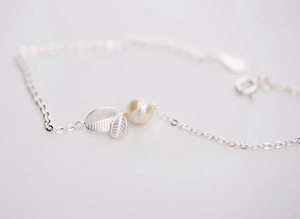 Vue macro du bracelet feuille en argent avec perle douce et chaîne de détail fine