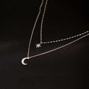 Detailed macro view of the 925 silver double-layer necklace with star and moon charms