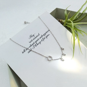 Detail of 925 silver anklet with geometric circle pendant and small zircon charms