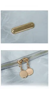 Detail of light blue Oxford backpack with golden metal accents and double zippers