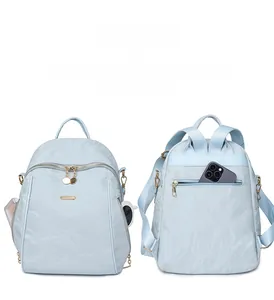 Light blue oxford backpack detail showing multiple external pockets and anti-theft back zipper