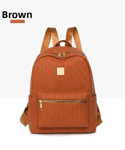 Detail of brown PU leather backpack with woven texture and gold zipper hardware