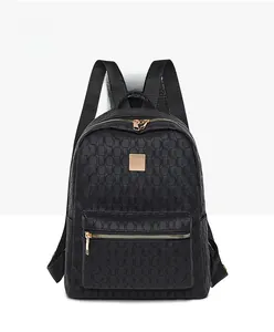 Detail of black backpack featuring 3D geometric woven texture and gold hardware accents