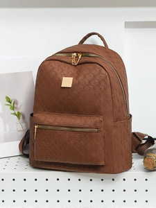 Close-up of geometric embossed texture and gold zippers on brown PU leather backpack