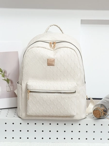 Detail of cream white backpack featuring 3D geometric embossing and gold metal hardware