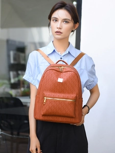 Brown faux leather backpack with geometric embossing shown on model for daily commuting