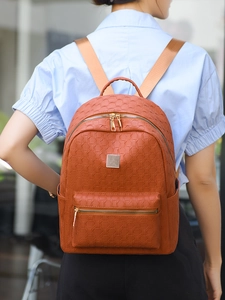 Close-up of brown woven PU leather backpack featuring metal plate and front zip pocket
