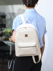 Detail of white PU backpack featuring geometric embossed patterns and gold hardware