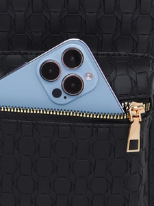 Close-up of black woven PU leather backpack with a gold zipper and a smartphone inside