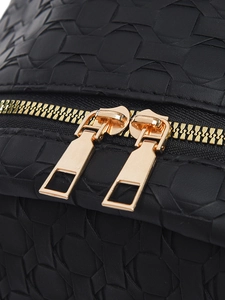 Close-up of black woven texture and golden double zipper hardware on women's backpack