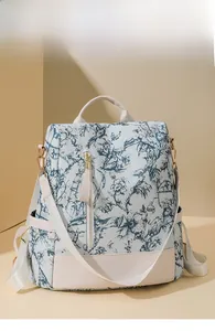 Détail du sac à dos vintage avec motif oiseaux bleus et fond en similicuir beige
