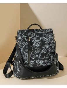 Détails du sac à dos noir avec motifs floraux blancs et finitions en cuir élégantes