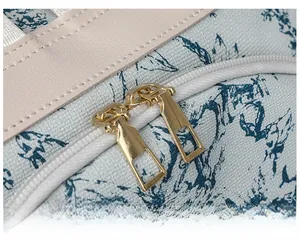 Détail de double fermeture éclair dorée sur un sac à dos en toile fleurie bleue