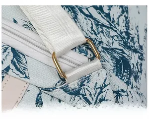Gros plan sur la boucle dorée et le tissu Toile de Jouy d'un sac à dos vintage chic
