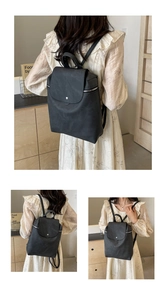 Detail of black matte PU leather backpack with flap closure and silver snap buttons