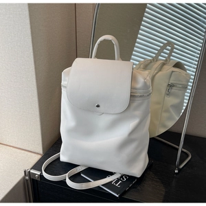 Macro detail of white PU leather backpack showing smooth matte finish and metal buckle