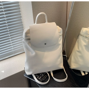 Detail of white PU leather backpack with magnetic flap and silver zipper accents