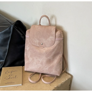 Detail view of pink vintage PU leather backpack with matte texture and magnetic closure