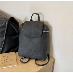 Detail of minimalist black matte leather backpack with silver snap and side zippers