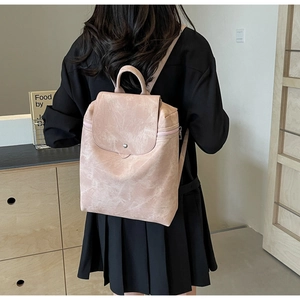 Detailed back view of a pink textured leather backpack with vintage metal hardware buckles