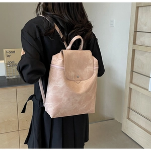 Detailed back view of a pale pink faux leather backpack with matte marble texture