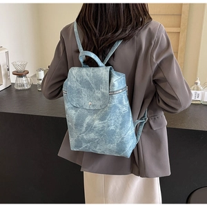 Rear view of a blue marble texture backpack featuring a silver buckle on its flap