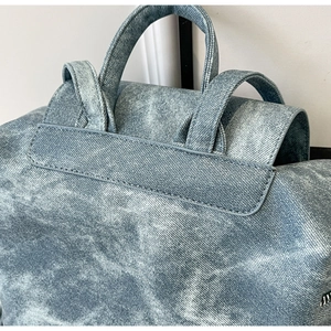 Close-up of blue washed denim texture on backpack straps and reinforced handle