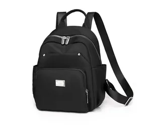 Side view of a black nylon backpack featuring metallic zippers and minimalist design