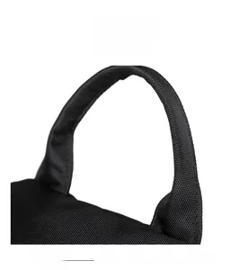 Close-up of the reinforced nylon handle on a black minimalist commuter backpack for women