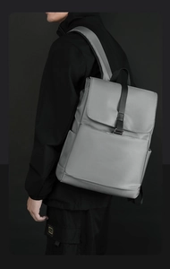 Vue latérale du sac à dos gris minimaliste avec fermeture à boucle et larges bretelles