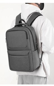 Detail of dark grey business backpack showing side USB port and waterproof fabric texture