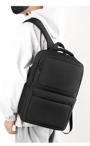 Side view of black business backpack with ergonomic padded straps on male model