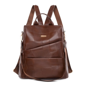 Detail of vintage brown leather patchwork backpack with gold buckle and adjustable strap