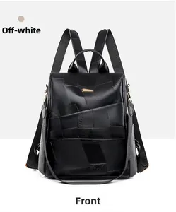 Front view of black patchwork leather backpack with gold hardware and top handle