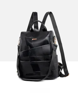 Detail of black leather patchwork backpack with gold metal hardware and nylon straps
