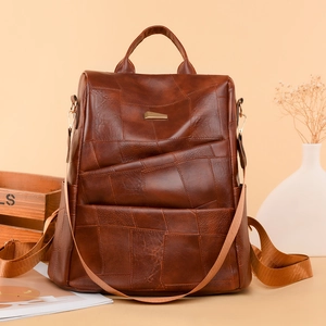 Detail of vintage brown patchwork leather backpack on wooden tray display