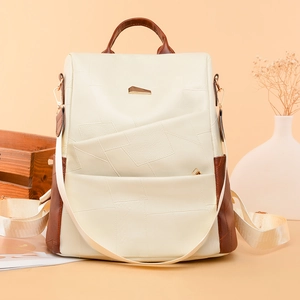 Detail of minimalist leather backpack with contrast brown trim and gold hardware accents