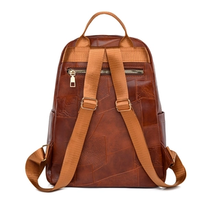 Rear view of brown PU leather backpack with geometric patchwork and hidden zipper pocket