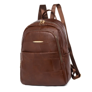 Detailed close-up of dark brown PU leather backpack with patchwork and gold zippers