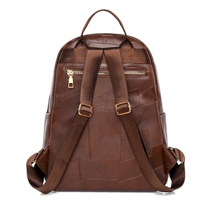Detail view of brown PU leather backpack with patchwork design and back zipper pocket