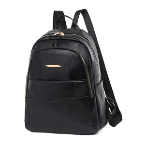 Detail of black PU leather backpack featuring geometric patchwork and gold metal hardware