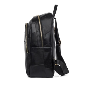 Detail view of black PU leather backpack with geometric patchwork and gold metal zippers