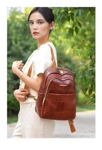 Detail of brown PU leather backpack featuring unique square patchwork texture and gold zipper