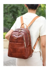 Detail of vintage brown PU leather backpack with irregular patchwork and gold zipper